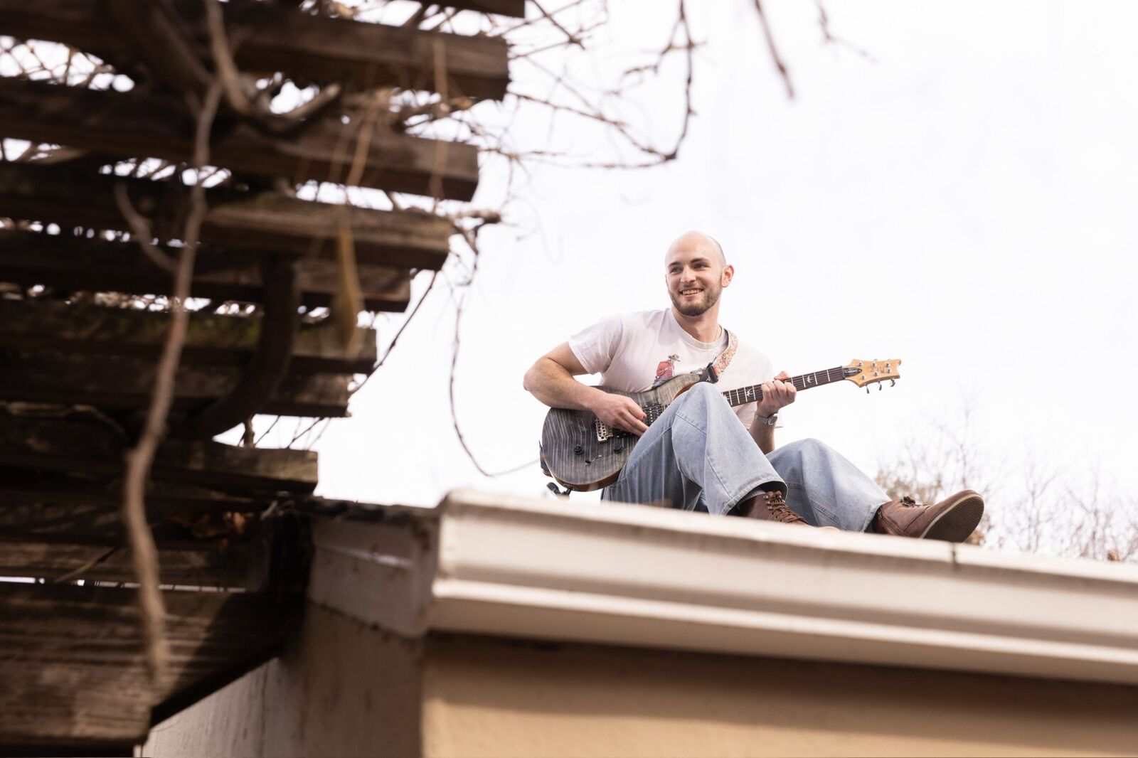 Playing electric guitar sitting on a rooftop