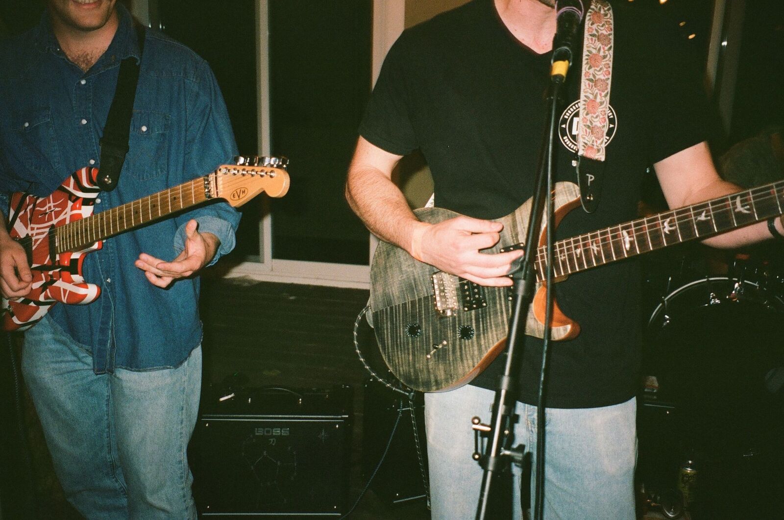 Close-up of two guitarists playing electric guitars on stage